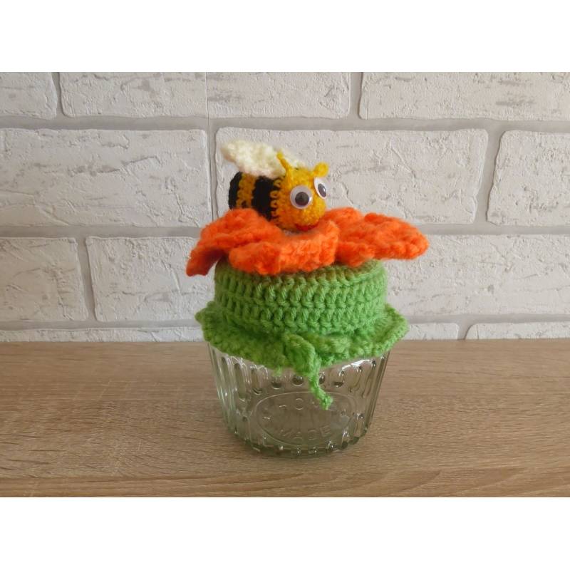 Schönes Glas mit Schraubverschluss, gehäkelter Blume (orange) und Biene