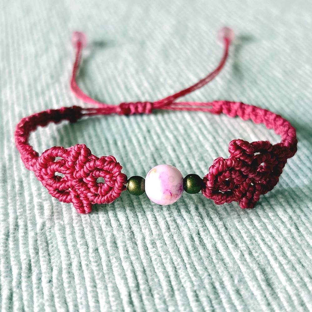 zierliches Makramee Armband in der Farbe beere mit marmorierter Acrylperle und bronzefarbenen Metallperlen Bild 1