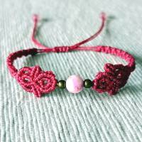 zierliches Makramee Armband in der Farbe beere mit marmorierter Acrylperle und bronzefarbenen Metallperlen