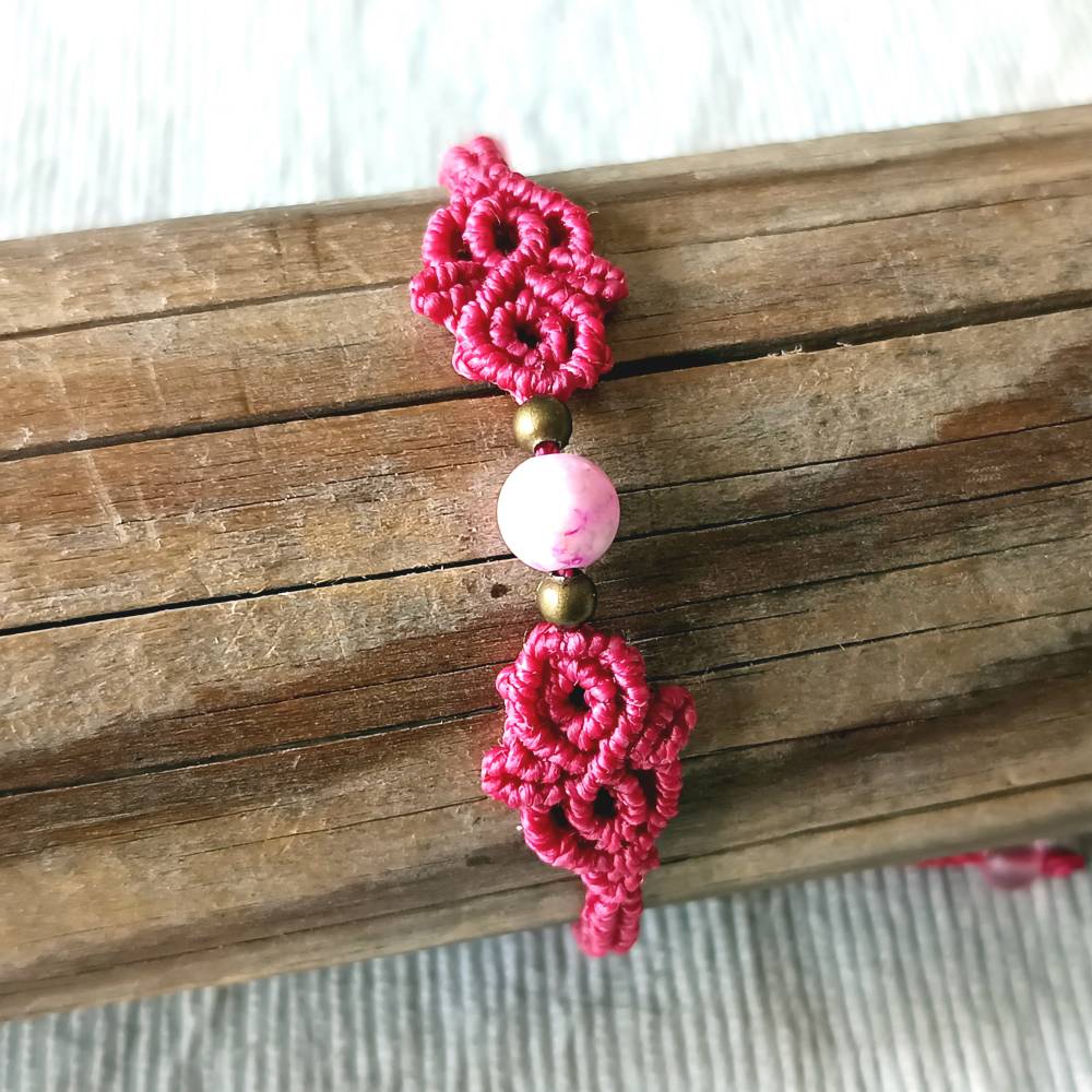 zierliches Makramee Armband in der Farbe beere mit marmorierter Acrylperle und bronzefarbenen Metallperlen Bild 2