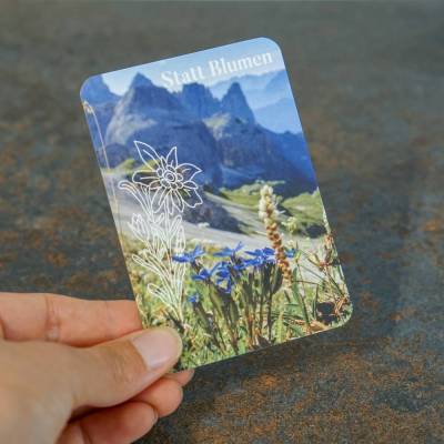 Postkarte "Statt Blumen" DinA7 mit Edelweiß und Enzian vor Berggipfeln