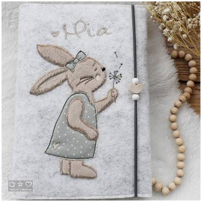 U-Hefthülle aus hellgrauem Wollfilz mit Doodlestickerei Hasenmädchen mit Pusteblume, personalisierbar