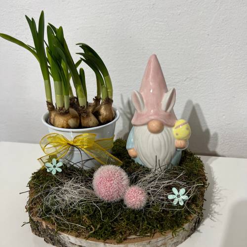 Osterdeko auf einer Baumscheibe mit Blumentopf und einem Wichtel