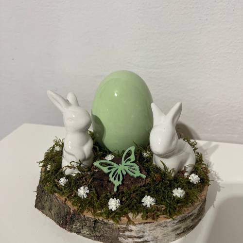 Osterdeko auf einer Baumscheibe Hasen grün