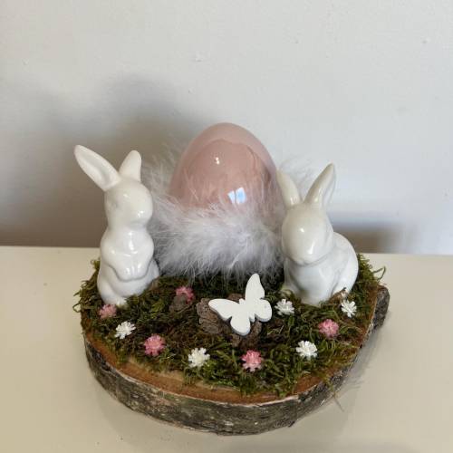 Osterdeko auf einer Baumscheibe Hasen