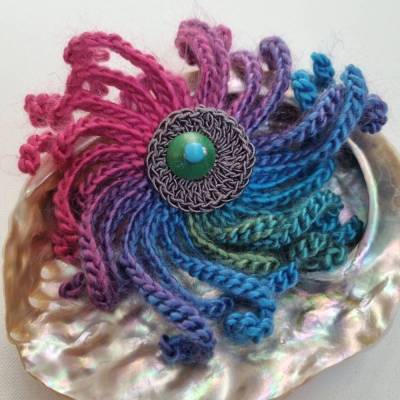 Eine schöne große, bunte, wilde Häkelblumenbrosche aus wirkungsvoller Wolle