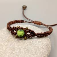 zierliches Makramee Armband in dunkelbraun mit einer grünen Acrylperle und bronzefarbenen Metallperlen