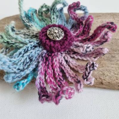 Schöne Ansteckbrosche: Wilde bunte Häkelblume in schönen Farben