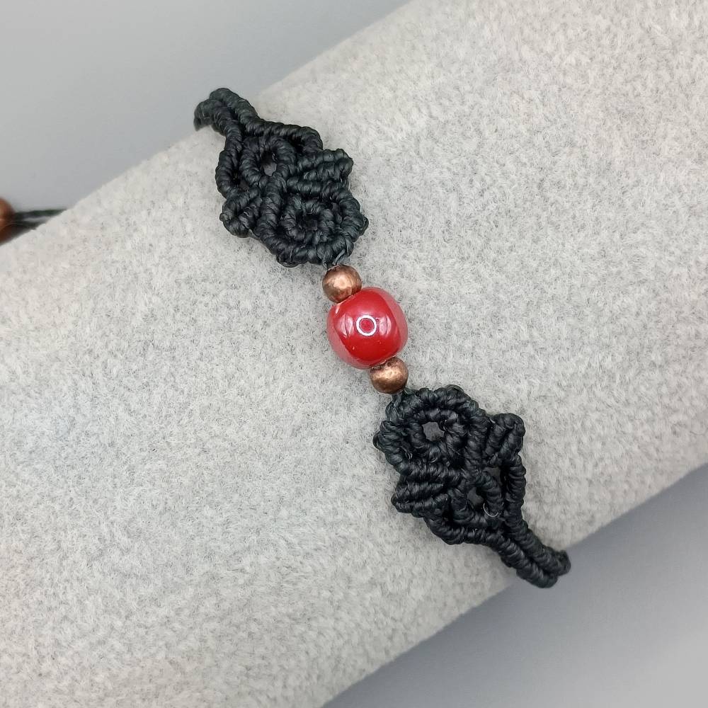 zierliches Makramee Armband in schwarz mit einer roten Keramikperle und kupferfarbenen Metallperlen Bild 1