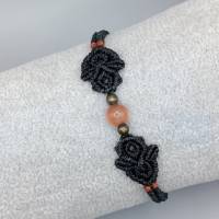 zierliches Makramee Armband in schwarz mit einer orangen Glasperle und bronzefarbenen Metallperlen