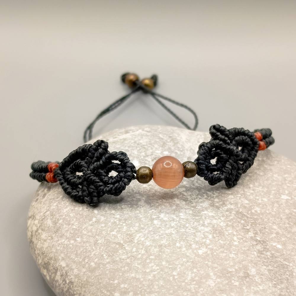 zierliches Makramee Armband in schwarz mit einer orangen Glasperle und bronzefarbenen Metallperlen Bild 2