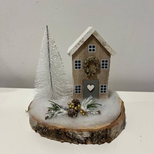 Weihnachtsdeko auf einer Baumscheibe mit einem Häuschen