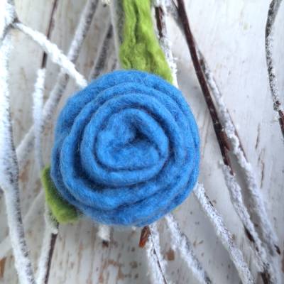 Handgefilzte Filzblume aus Wolle – blaue Filzbrosche mit grünem Blatt