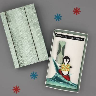 Geschenkbox Reisegeld: Surfender Pinguin als origineller Urlaubszuschuss