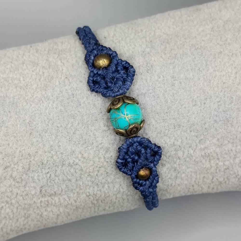 zierliches Makramee Armband in dunkelblau mit einer marmorierten Acrylperle und bronzefarbenen Metallperlen Bild 2