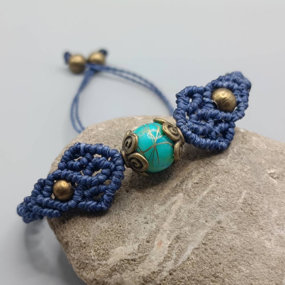 zierliches Makramee Armband in dunkelblau mit einer marmorierten Acrylperle und bronzefarbenen Metallperlen Bild 3