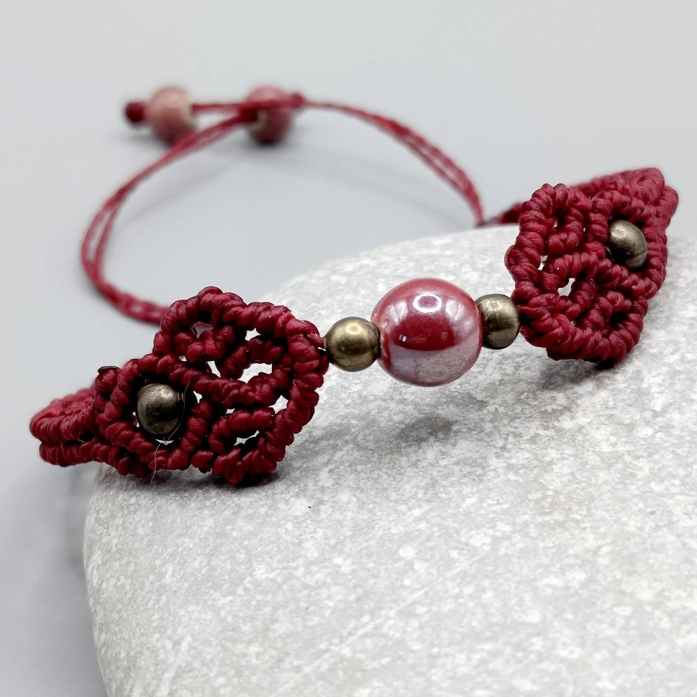 zierliches Makramee Armband in weinrot mit einer Acrylperle und bronzefarbenen Metallperlen Bild 2