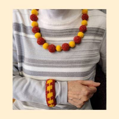 Sonnenperlen – handgehäkeltes Schmuckset aus Kette und Armband in Rot-Gelb