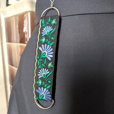 Rockheber aus schwarzem Leinen mit farbenfroher Blütenstickerei – Skirtlifter für Rock & Kleid