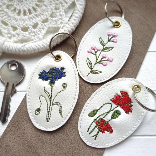 Schlüsselanhänger Wiesenblumen gestickt, Mohnblume Kornblume auf weissem Kunstleder, Taschen Anhänger als Taschenbaumler