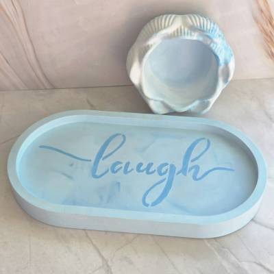 2-teiliges Set aus Dekotablett oval mit Schriftzug „Laugh“ und Lotusblume aus Raysin in cyan-weißem Farbverlauf