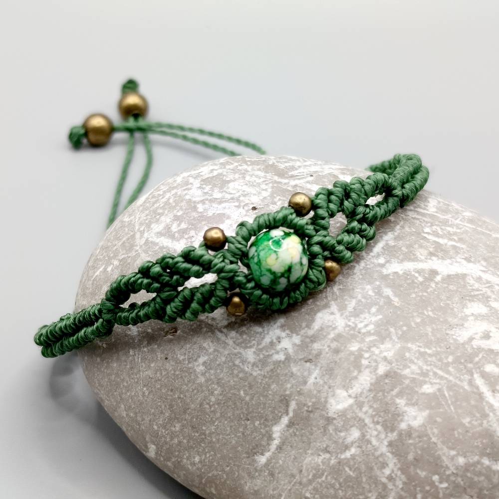 zierliches Makramee Armband in grün mit einer marmorierten Acrylperle und bronzefarbenen Metallperlen Bild 1