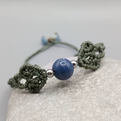 filigranes Makramee Armband in khakigrün mit einer blauen Acrylperle und silberfarbenen Metallperlen