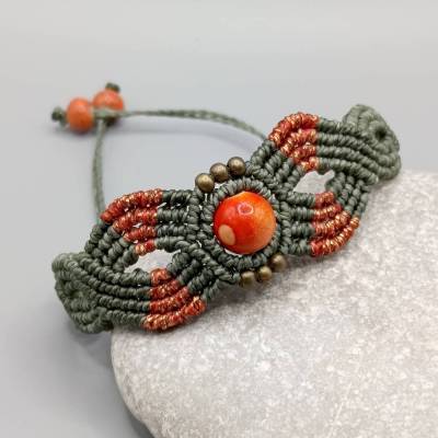 Makramee Armband in khakigrün und metallic orange mit einer marmorierten Acrylperle und bronzefarbenen Metallperlen
