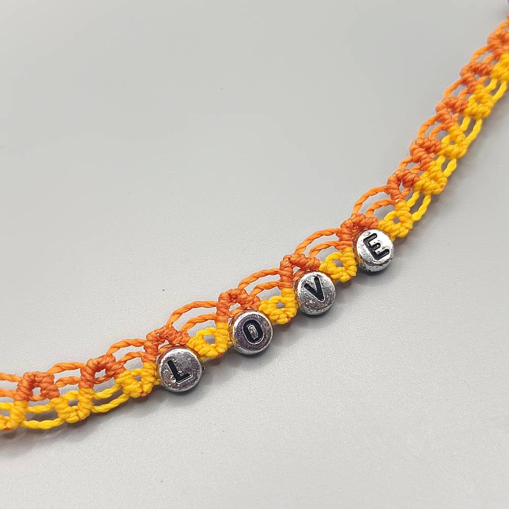 Makramee Fussbändchen in orange und gelb mit silberfarbenen Perlen und der Inschift LOVE Bild 2