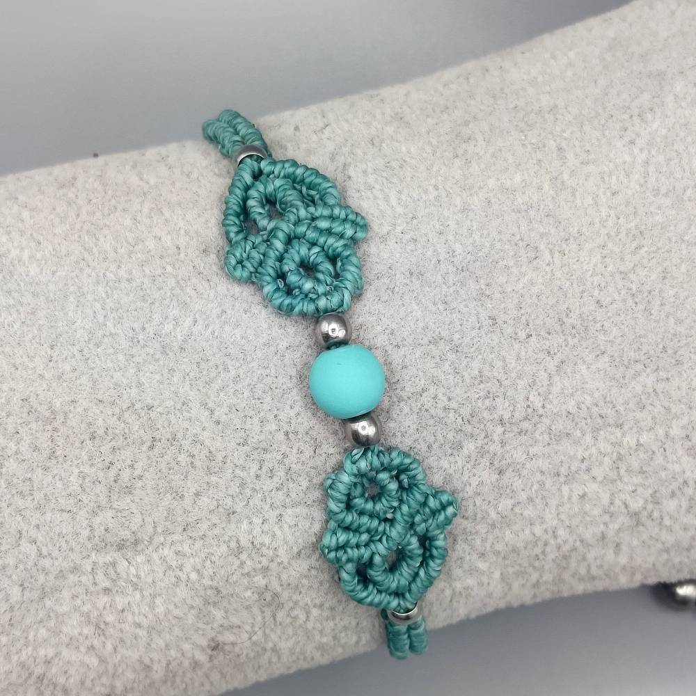 zierliches Makramee Armband in türkis mit einer mattierten Acrylperle und silberfarbenen Metallperlen Bild 1
