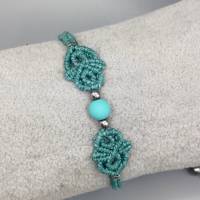 zierliches Makramee Armband in türkis mit einer mattierten Acrylperle und silberfarbenen Metallperlen