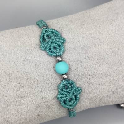 zierliches Makramee Armband in türkis mit einer mattierten Acrylperle und silberfarbenen Metallperlen