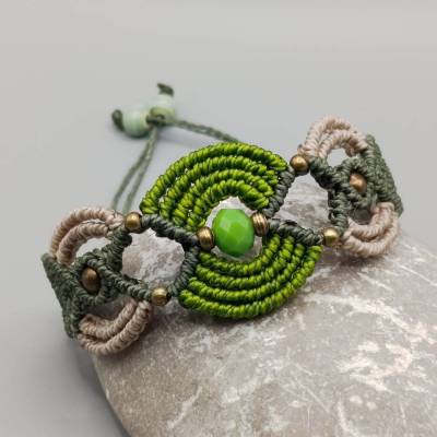 Makramee Armband in pistaziengrün, olivgrün und beige mit einer facettierten Acrylperle und bronzefarbenen Metallperlen