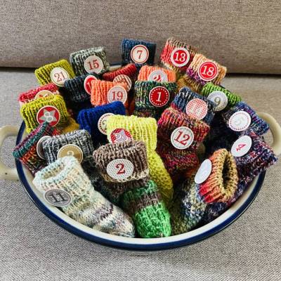 Adventskalender aus 24 handgestrickten bunten Minisocken – nachhaltig, wiederverwendbar, waschbar