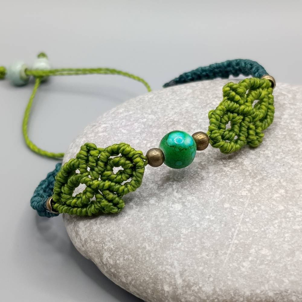 Makramee Armband in pistaziengrün und petrol mit einer marmorierten Acrylperle und bronzefarbenen Metallperlen Bild 1