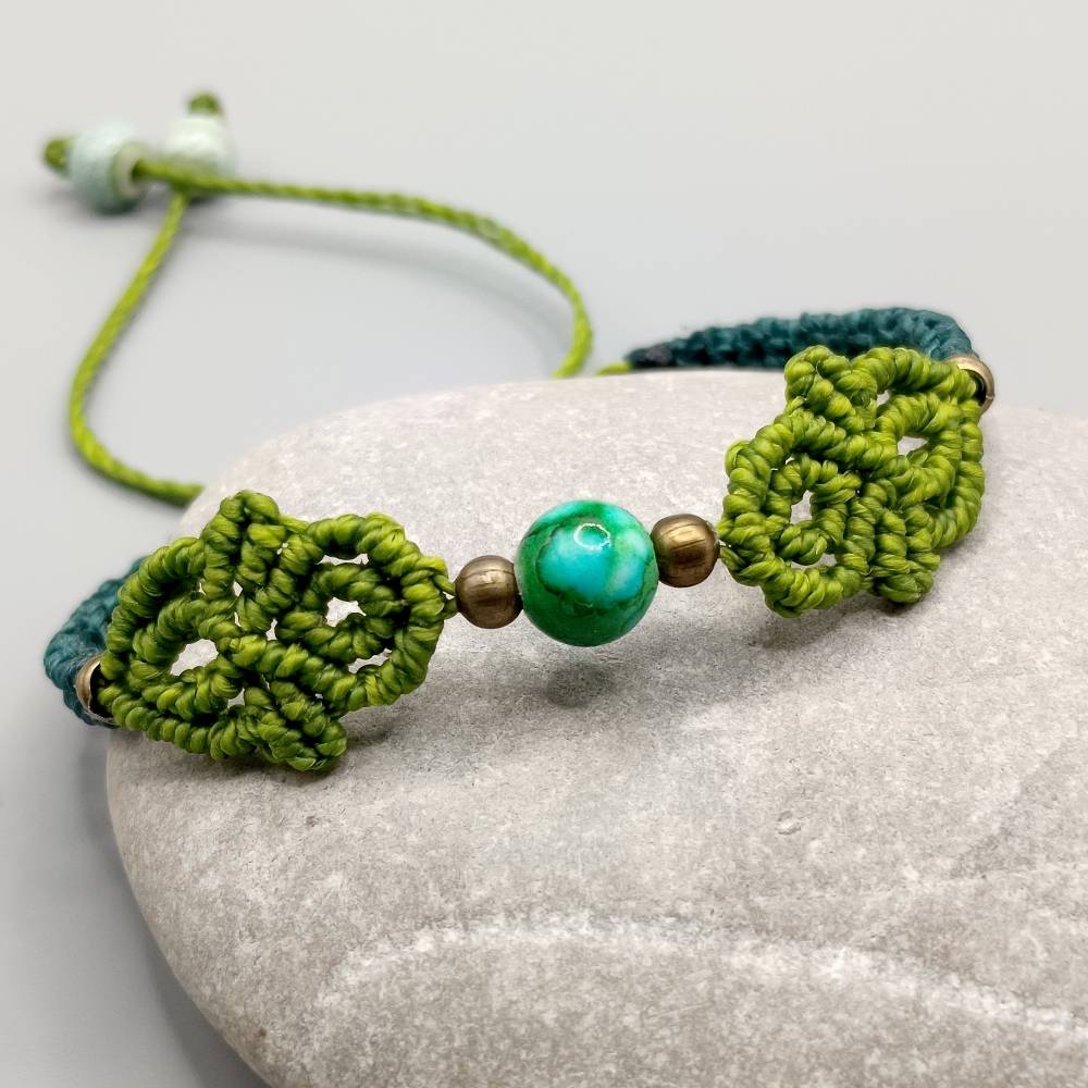 Makramee Armband in pistaziengrün und petrol mit einer marmorierten Acrylperle und bronzefarbenen Metallperlen Bild 3