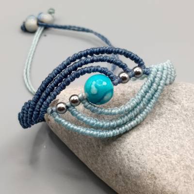 filigranes Makramee Armband in Blautönen mit einer marmorierten Acrylperle und silberfarbenen Metallperlen