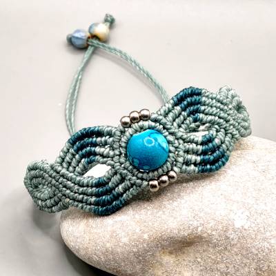 Makramee Armband in blaugrau und petrol mit einer marmorierten Acrylperle und kleinen Edelstahlperlen