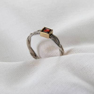 Fingerring  "Zopf II“ Weite 54,5, aus 935 Silber mit einem Granat-Carrée, gefasst in 750er Gelbgold