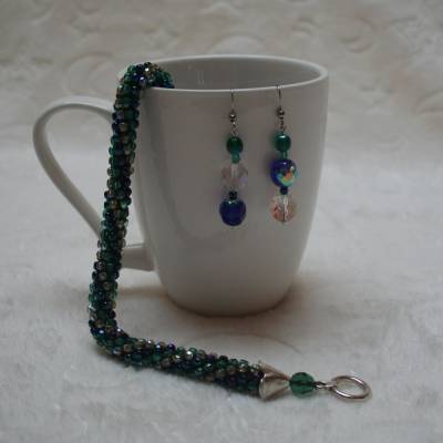 Perlenset aus grün-blau-silber schimmernden Kristallen in Schlauchtechnik