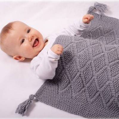 Strickanleitung für die Babydecke Sternenglanz mit Rautenmuster und Quasten, in der Größe 54x74 cm