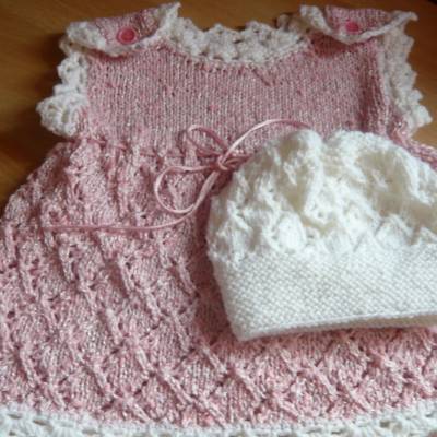       Süßes handgestricktes Babykleidchen mit weißer Mütze,