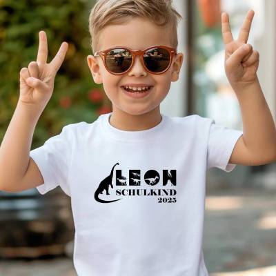 Personalisiertes T-Shirt für Jungen oder Mädchen zum Schulanfang. Schulkind 2026 mit Wunschname und Dinosaurie
