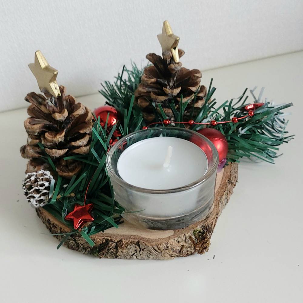 Adventsgesteck mit Zapfen und Teelicht auf Baumscheibe