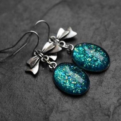 Ovale Ohrringe mit Schleife . Hängeohrringe mit türkisem Glitzer . Niedliche Schleifchen Ohrhänger mit Glitter