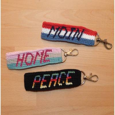 kurzes Schlüsselband mit eingehäkeltem Text: Moin, Home, Peace, Biobaumwolle, Handarbeit