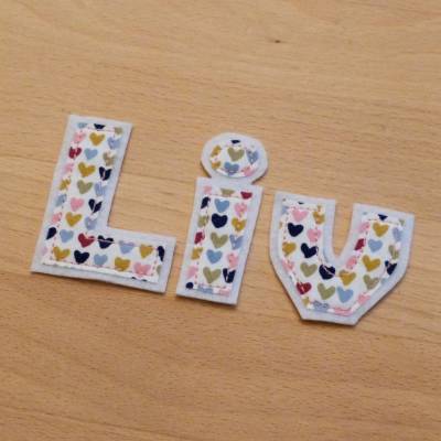 Buchstaben zum Aufbügeln aus Biobaumwolle mit bunten Herzchen – Handgemachte Namensapplikation