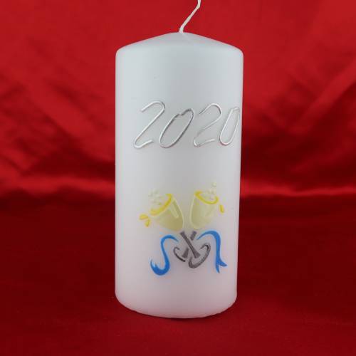 Weiße Silvesterkerze mit Jahreszahl und Sektgläsern